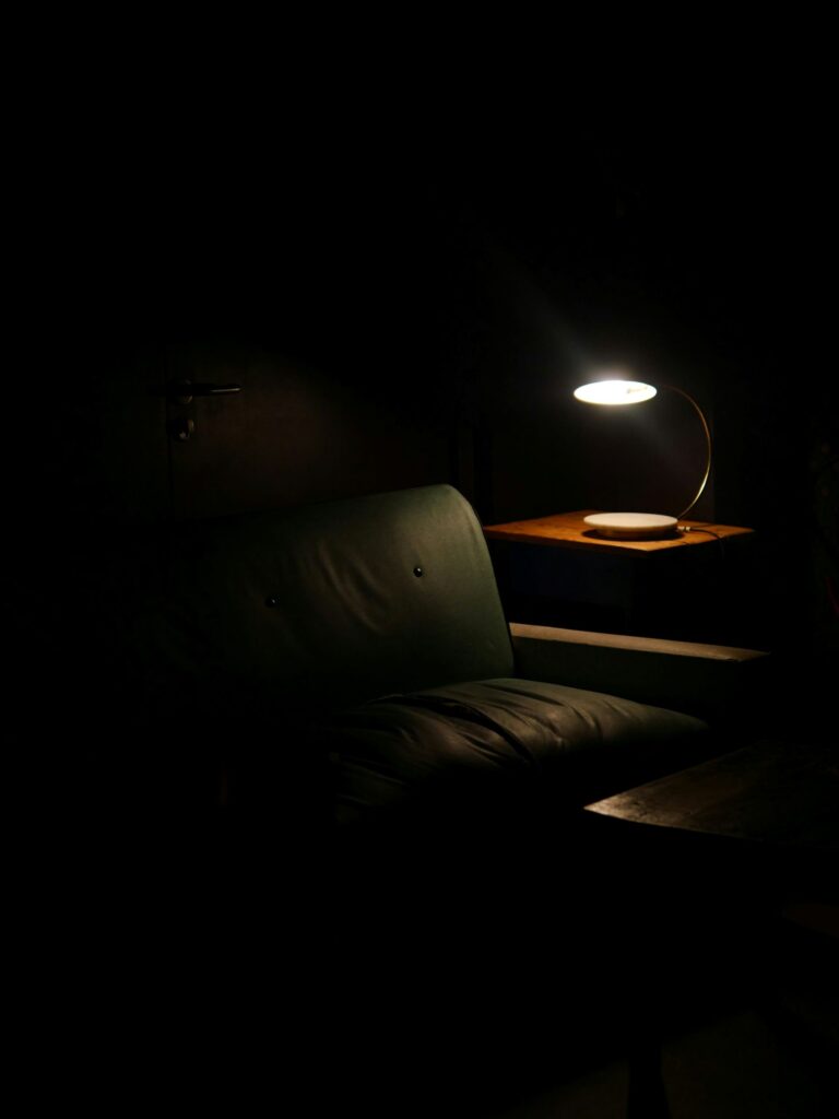 quiet chair illuminated by a small lamp, symbolizing reflection and rebuilding momentum through stillness