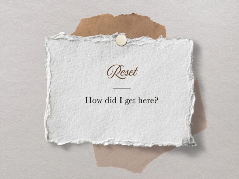 “Reset concept with text ‘How did I get here?’ on textured paper, representing reflection during a life reset.”