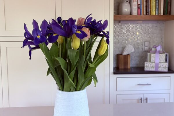 A simple vase of fresh flowers in a calm, organized kitchen space representing focus, clarity, and staying aligned with what matters