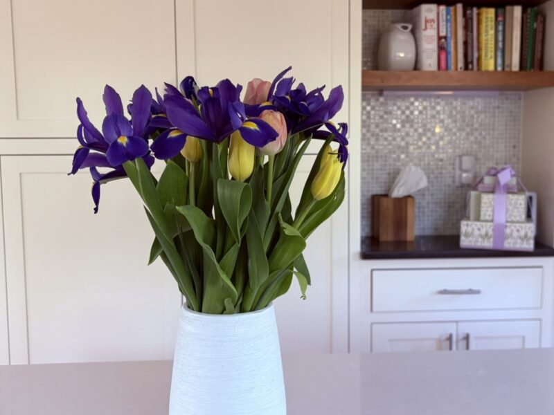A simple vase of fresh flowers in a calm, organized kitchen space representing focus, clarity, and staying aligned with what matters