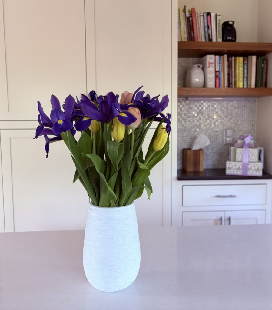 A simple vase of fresh flowers in a calm, organized kitchen space representing focus, clarity, and staying aligned with what matters