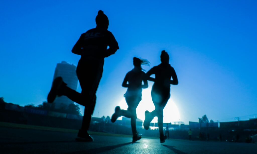 Women running at sunrise illustrating how action builds confidence through repeated movement and effort